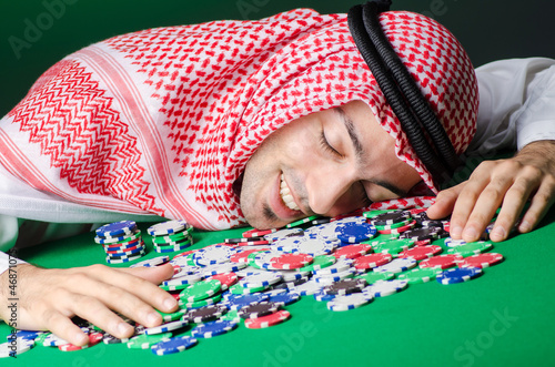 Photo: Arab playing in casino - gambling concept with man Arab playing in casino - gambling concept with man