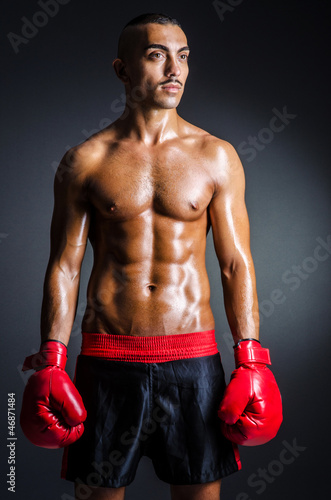 Photo: Boxer with red gloves in dark room Boxer with red gloves in dark room