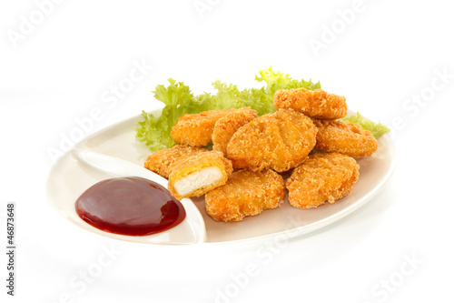 Photo: Plate of nuggets with dip sauce, one nugget cut Plate of nuggets with dip sauce, one nugget cut