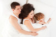 Foto: Happy family, mother, father and daughter resting on the white b Happy family, mother, father and daughter resting on the white b
