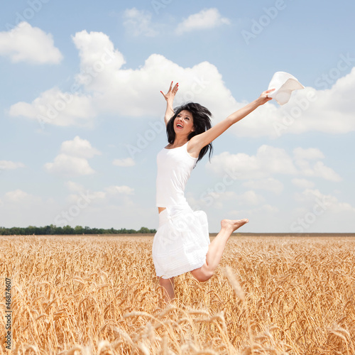 Photo: Happy woman jumping in golden wheat Happy woman jumping in golden wheat