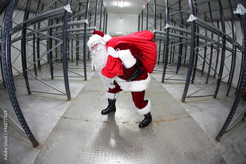 Photo: Santa Claus with red sack in empty storehouse Santa Claus with red sack in empty storehouse