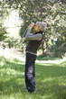 A mature woman outdoors, looking through a pair of binoculars