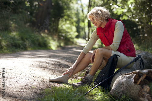 Photo: A woman hiker massaging her sore feet A woman hiker massaging her sore feet