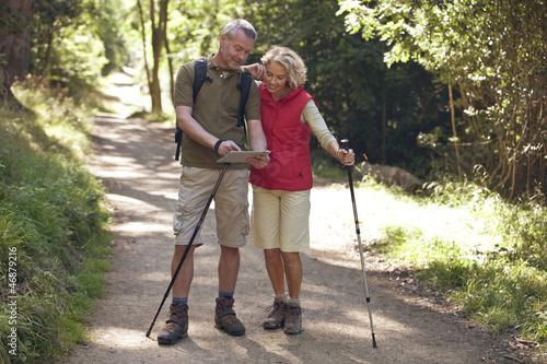Photo: A mature couple out walking navigating with an ipad A mature couple out walking navigating with an ipad