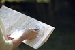 A woman holding a map and compass, close up