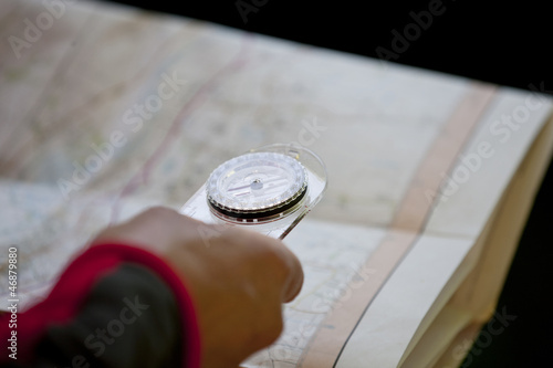 Photo: A man holding a map and compass, close up A man holding a map and compass, close up