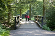 A mature couple walking over a footbridge in the countryside