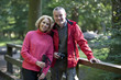 A mature couple standing on a footbridge in the countryside