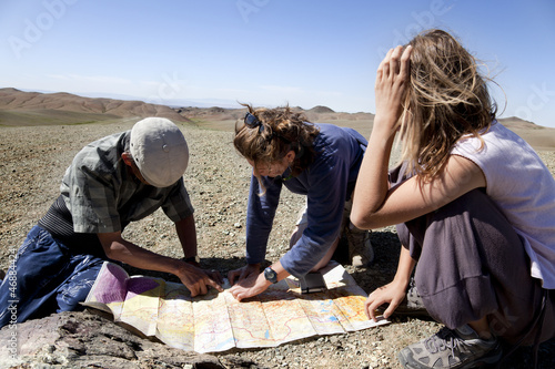 Photo: two girls and a man looking at a map of the Gobi desert two girls and a man looking at a map of the Gobi desert
