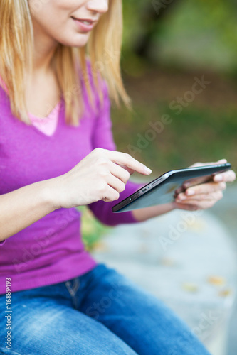 Photo: Woman using digital tablet outdoors Woman using digital tablet outdoors