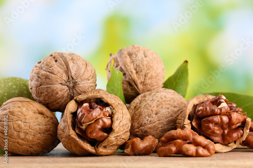 Photo: walnuts with green leaves, on green background walnuts with green leaves, on green background