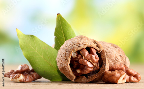 Photo: walnuts with green leaves, on green background walnuts with green leaves, on green background