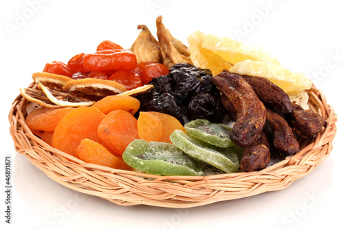 Photo: Dried fruits on wicker plate isolated on white Dried fruits on wicker plate isolated on white