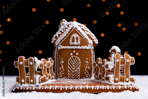 Photo: Gingerbread cookie house on dark background Gingerbread cookie house on dark background