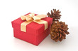 Photo: Christmas gift box and pine cones over white background. Christmas gift box and pine cones over white background.
