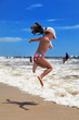 Fillette sautant dans le vagues.