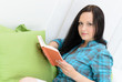 junge frau mit einem buch auf dem sofa