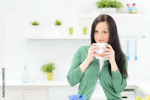 Photo: junge frau trinkt zum frühstück kaffee junge frau trinkt zum frühstück kaffee