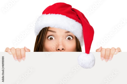Photo: Santa hat woman showing christmas sign Santa hat woman showing christmas sign
