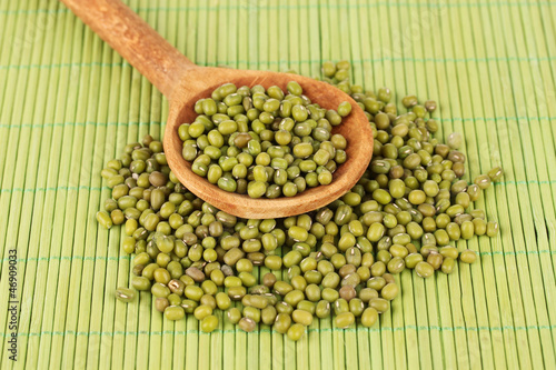 Photo: Mung beans over wooden spoon on color background Mung beans over wooden spoon on color background