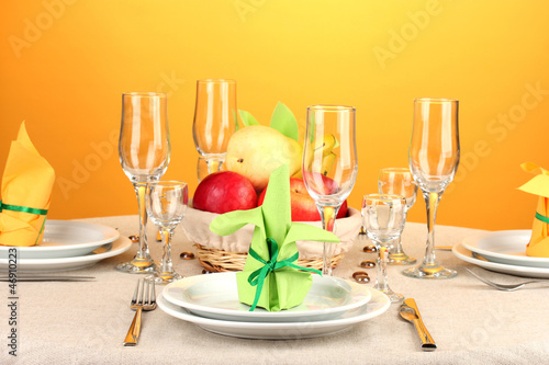 Photo: Table setting in green and yellow tones on color background Table setting in green and yellow tones on color background