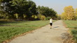 Businesswoman goes in the autumn park and talking on the phone
