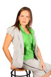 Young beautiful business woman sits on stool in studio on white