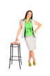 Young beautiful business woman stands leaning on tall stool