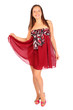 Beautiful young woman dressed in red pareo poses in studio