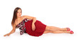 Beautiful young woman dressed in red pareo lies in studio