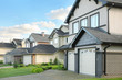 Street with two-storied brown cottages with built-in garage