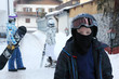 Boy wearing in sport suit and helmet stands in mountain village.