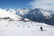 Cable car, buildings in mountains. Many skiers ride in Alps
