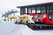 Two red machines for skiing slope preparations in Austrian Alps.