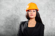 Photo: Beautiful brunette girl in coat, helmet pose in photo studio Beautiful brunette girl in coat, helmet pose in photo studio