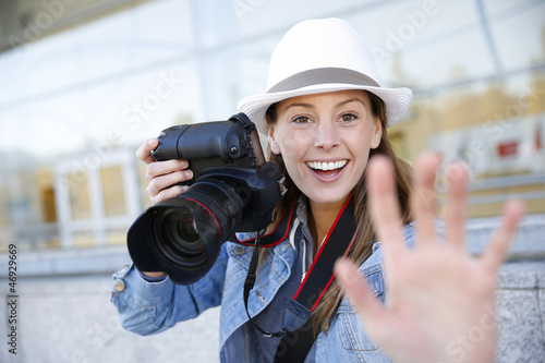 Photo: Cheerful photographer showing hand towards camera Cheerful photographer showing hand towards camera