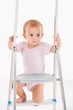 Beautiful baby girl climbing on ladder