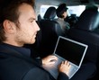 Young man working on laptop in limousine