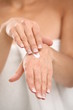 Close up of woman applying cream on her hand