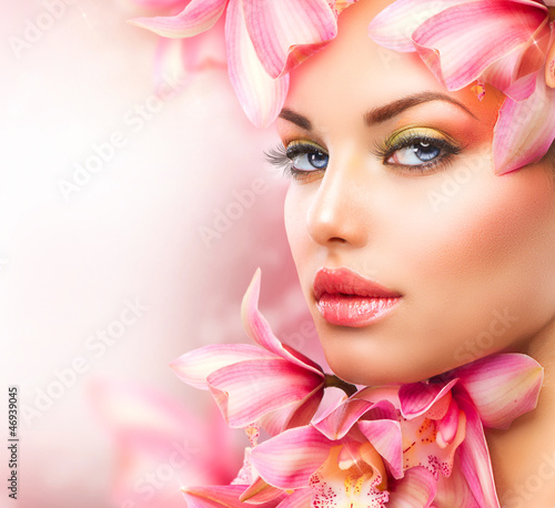 Photo: Beautiful Girl With Orchid Flowers. Beauty Woman Face Beautiful Girl With Orchid Flowers. Beauty Woman Face
