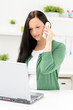 junge frau mit laptop telefoniert
