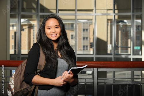 Photo: Young Oriental Woman Student holding a copybook Young Oriental Woman Student holding a copybook