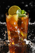 Fresh cold tea with lemon and mint in water splashing