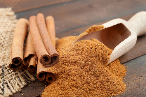 Photo: Cinnamon sticks and cinnamon powder in wooden scoop Cinnamon sticks and cinnamon powder in wooden scoop
