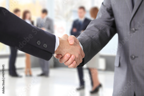 Photo: Closeup of business people shaking hands over a deal Closeup of business people shaking hands over a deal