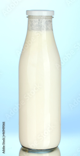 Photo: bottle of milk on blue background close-up bottle of milk on blue background close-up