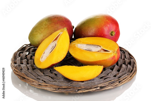 Photo: Ripe appetizing mango on wicker cradle isolated on white Ripe appetizing mango on wicker cradle isolated on white