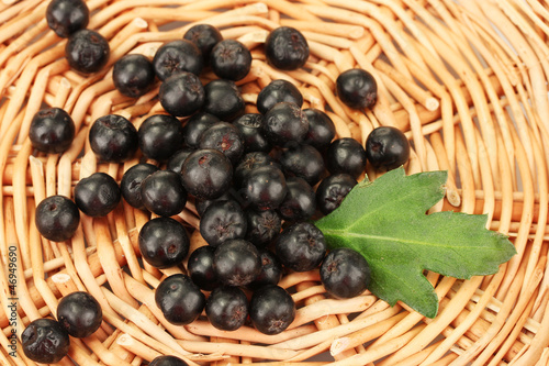 Photo: chokeberry with green leaf on wicker mat close-up chokeberry with green leaf on wicker mat close-up