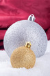 silber und goldene Christbaumkugel im Schnee
